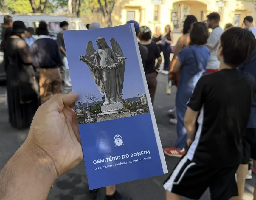 Visitante com o guia de educação patrimonial do Cemitério Bonfim