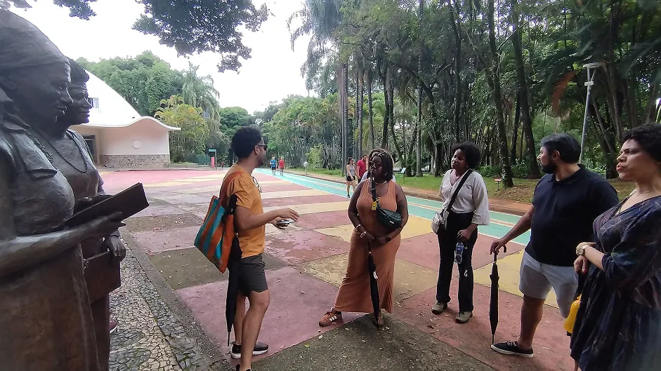 Grupo de participantes em uma das paradas do tour, interagindo com o patrimônio da cidade