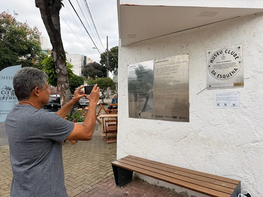 Visitante fotografando a famosa esquina das ruas Paraisópolis e Divinópolis