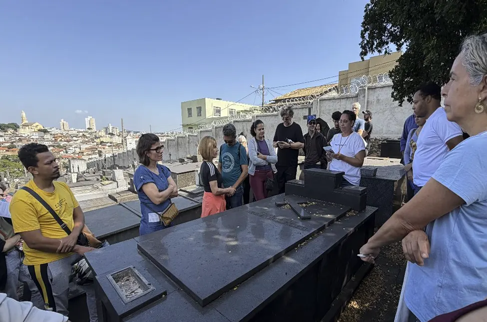 Marcelina Almeida durante palestra no Cemitério Bonfim, com vista panorâmica de Belo Horizonte