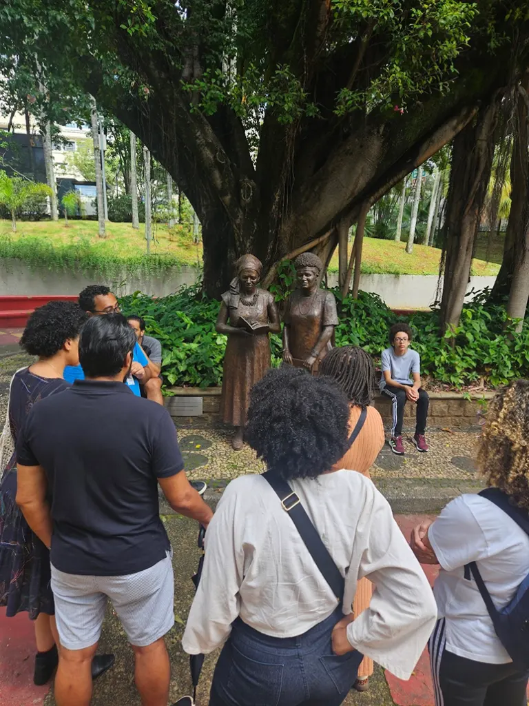 Participantes ao pé das estátuas no Museu dos Quilombos e Favelas Urbanas