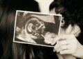 Sasha e João Lucas com a foto do ultrassom que mostra a gravidez