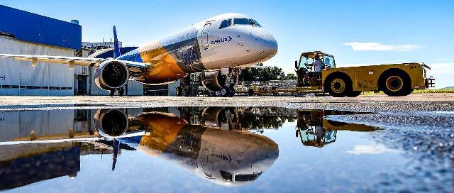 Avião da Embraer e seu reflexo na água