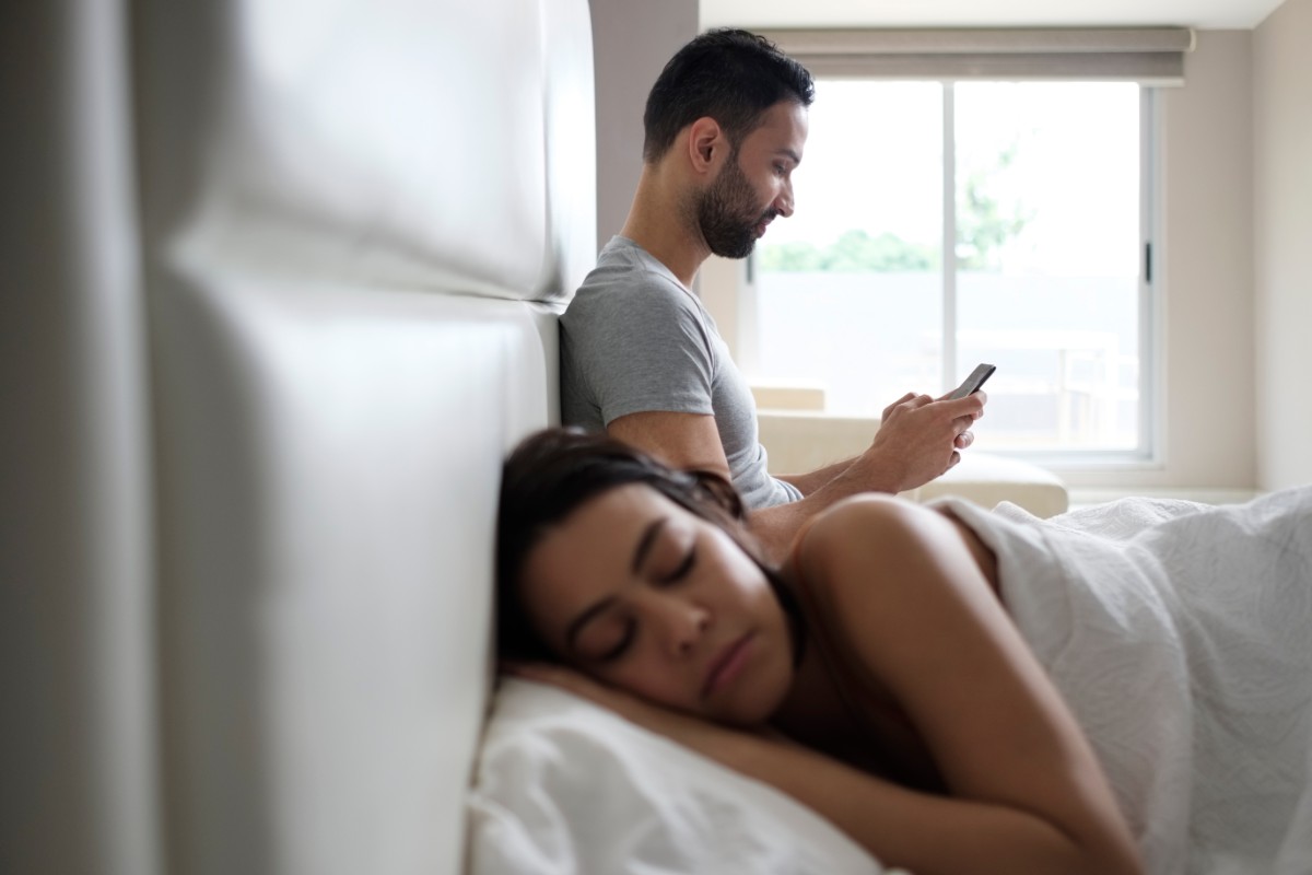 casal cama homem traindo celular