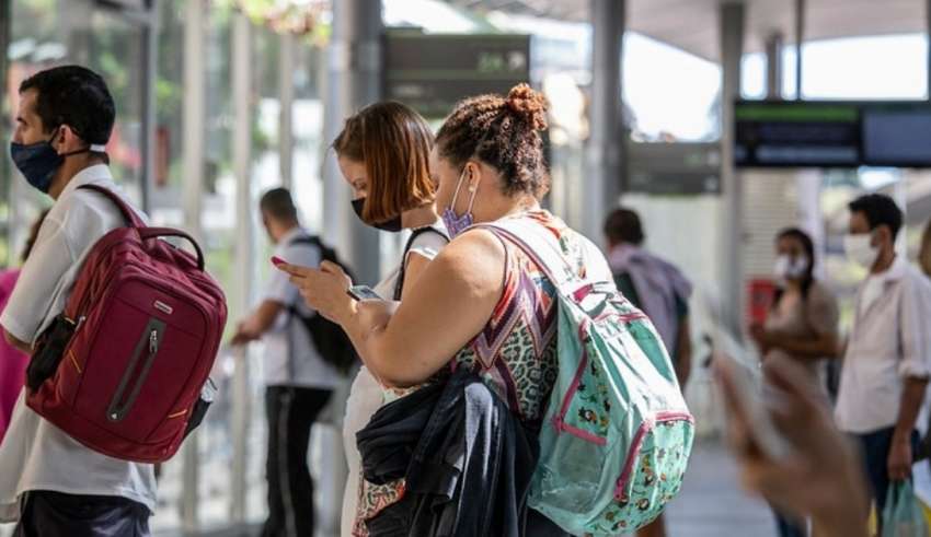 pessoas usando máscara esperando o ônibus