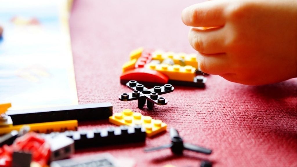 peças de lego e mão de criança