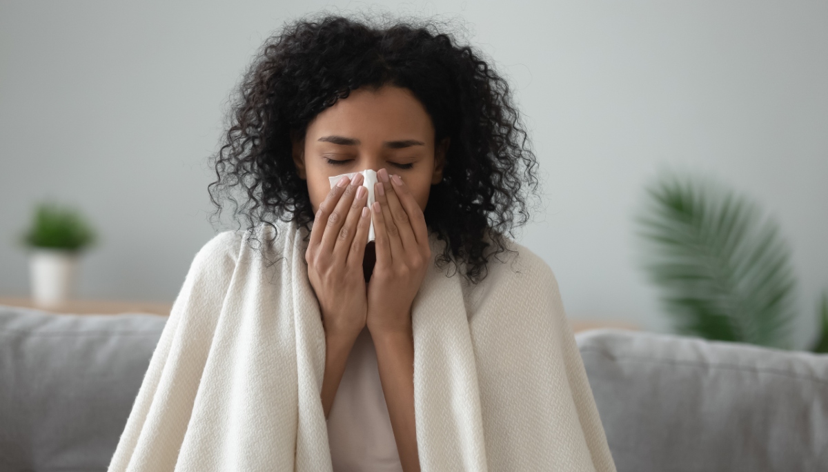 mulher limpando nariz dentro de casa gripe resfriado
