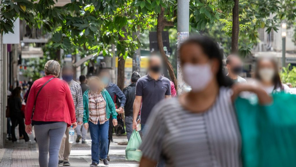 pessoas na rua com máscara compras
