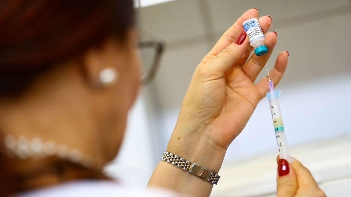 profissional da saúde preparando para aplicar vacina