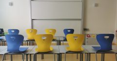Sala de aula com cadeiras em azul e amarelo