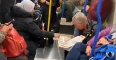 jovem ajuda idoso com parkinson a ler jornal em metrô