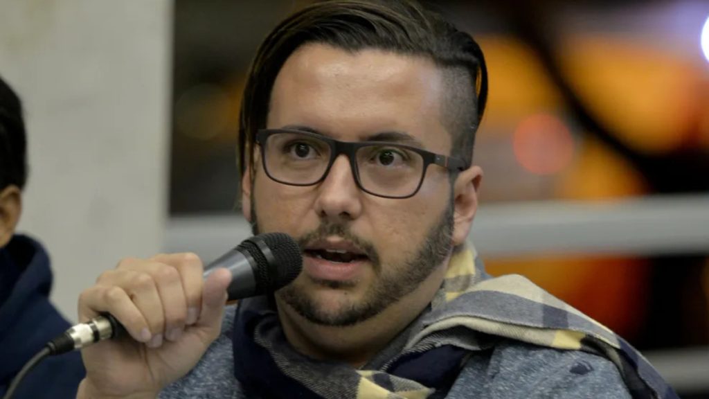 moisés segurando um microfone duranre palestra na assembleia