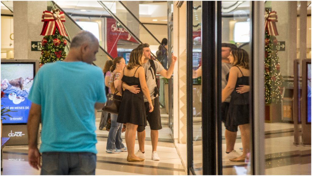 pessoas olhando vitrine de loja em shopping
