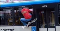 homem pendurado ônibus