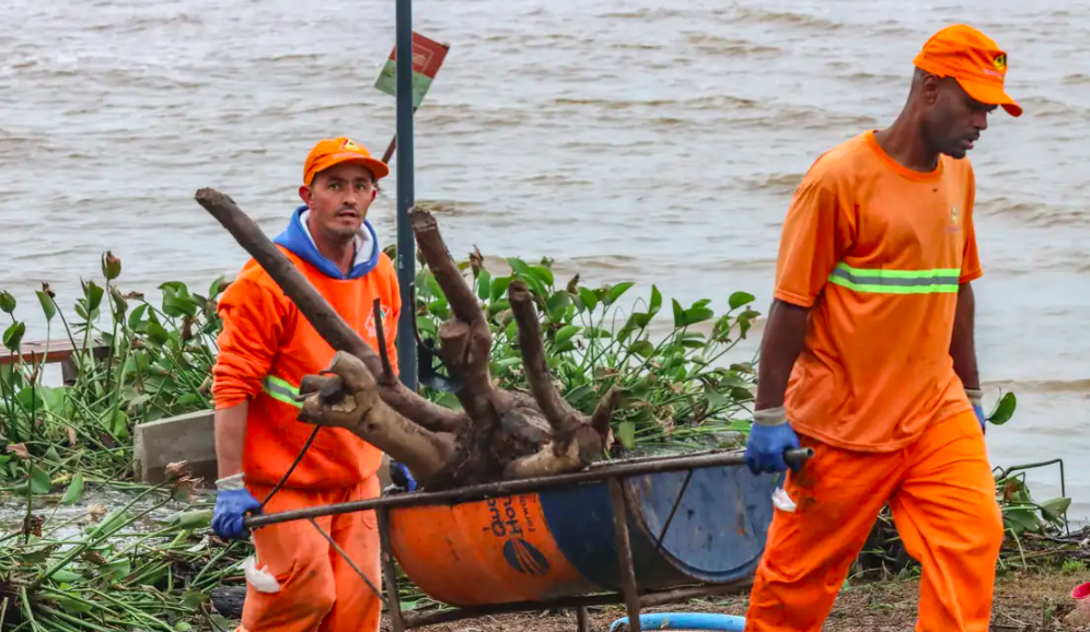 Trabalhadores fazem limpeza próximo ao rio Guaíba, no RS