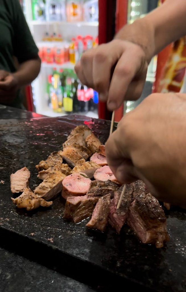 Servindo um churrasco de graça no balcão do Bar do Careca.