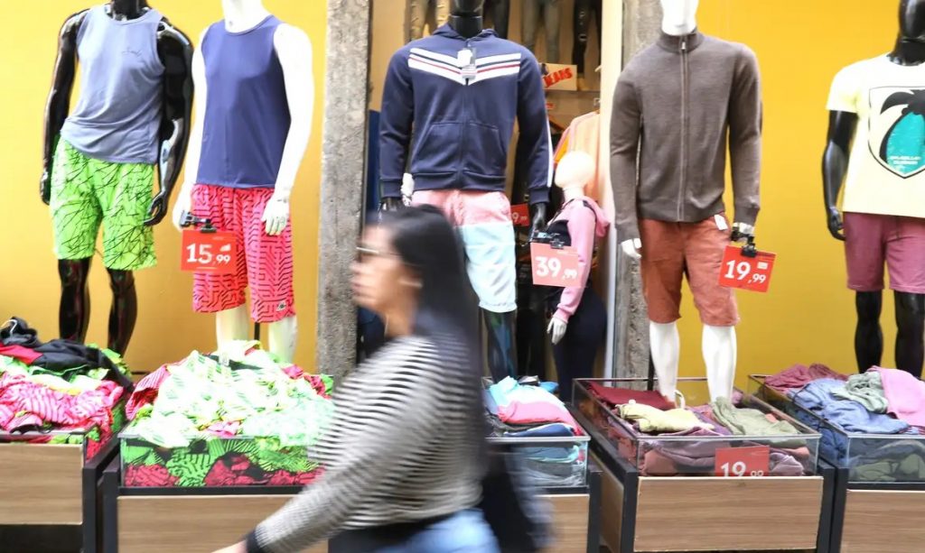 Mulher passa em frente a uma loja