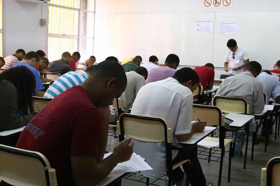 pessoas sentadas fazendo uma prova, ilustrando o concurso para professores da rede municipal