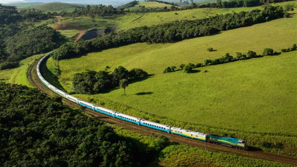 Trem da Vale passando por trecho rural com muita vegetação verde